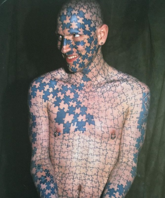 What does a man look like who covered the body with a tattoos in the form of puzzles