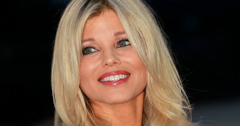 Donna dazzles in a crimson plunging bathing suit as she recreates a famous Baywatch photo