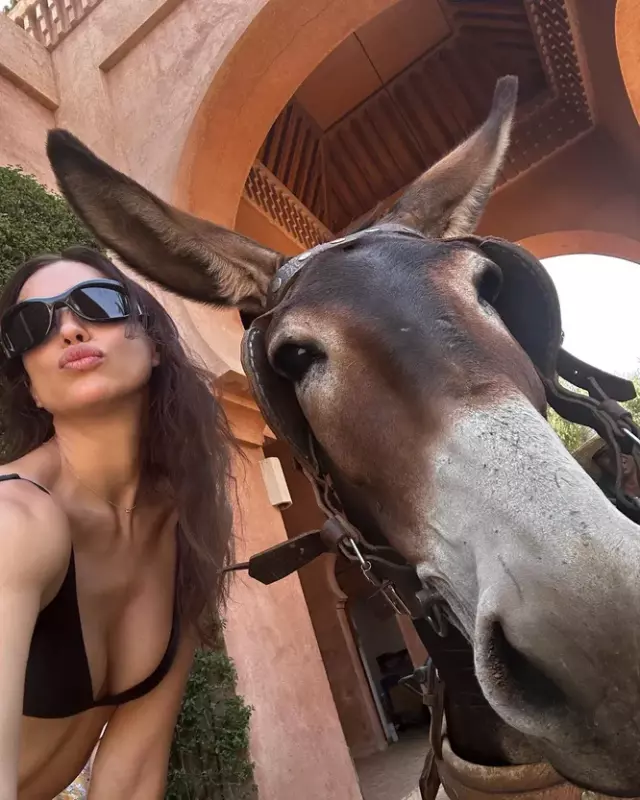 I'm in the red city! Irina in a biкini posed with a donkey and a camel