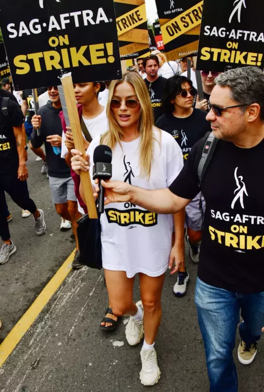 Margot forgets to wear trousers while wowing in an oversized T-shirt during a strike march