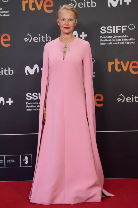 Pamela Anderson attends Sebastian film festival in a pink caped gown, sleek hair, and bold red lip